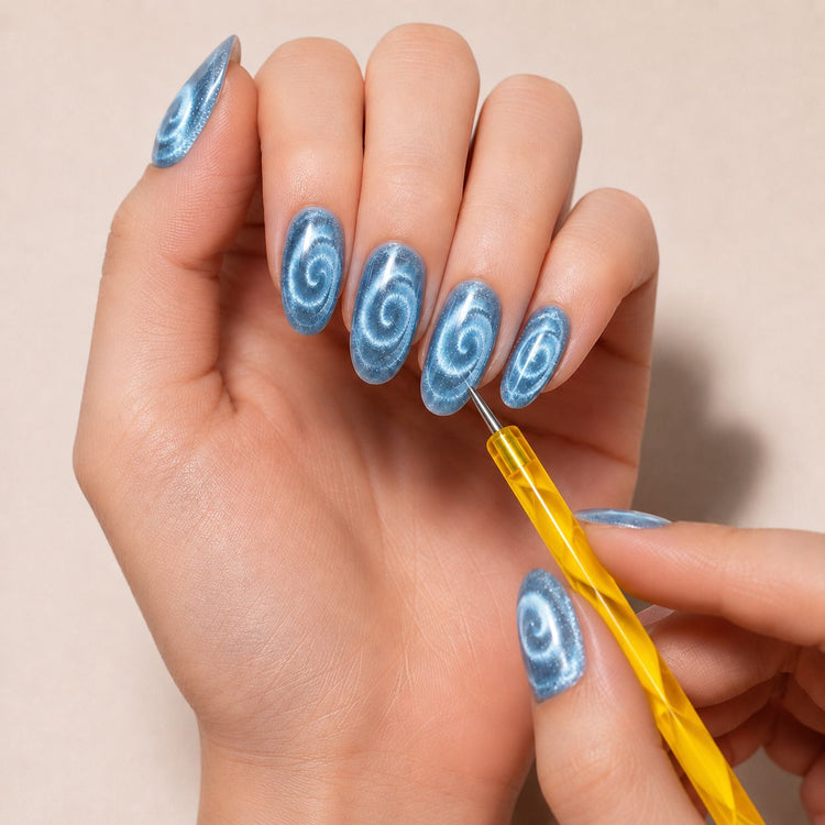 Yellow marbled cat-eye magnetic pen creating spiral effects on blue magnetic gel polish nails – NSI Australia
