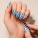 Black marbled cat-eye magnetic pen creating spiral effects on blue magnetic gel polish nails – NSI Australia