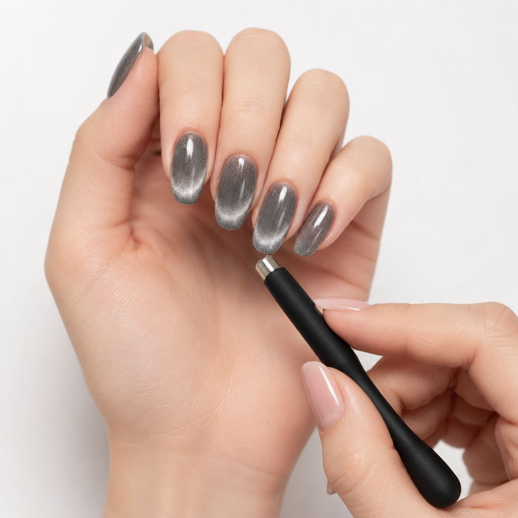 Cat-eye magnet tool creating a silver magnetic gel polish effect on almond-shaped nails