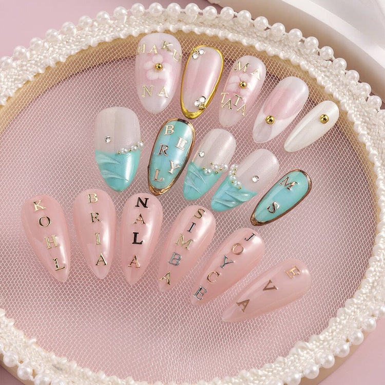 Metallic 3D alphabet nail art letters on pink and teal gel nails, personalized names with pearls and rhinestones display