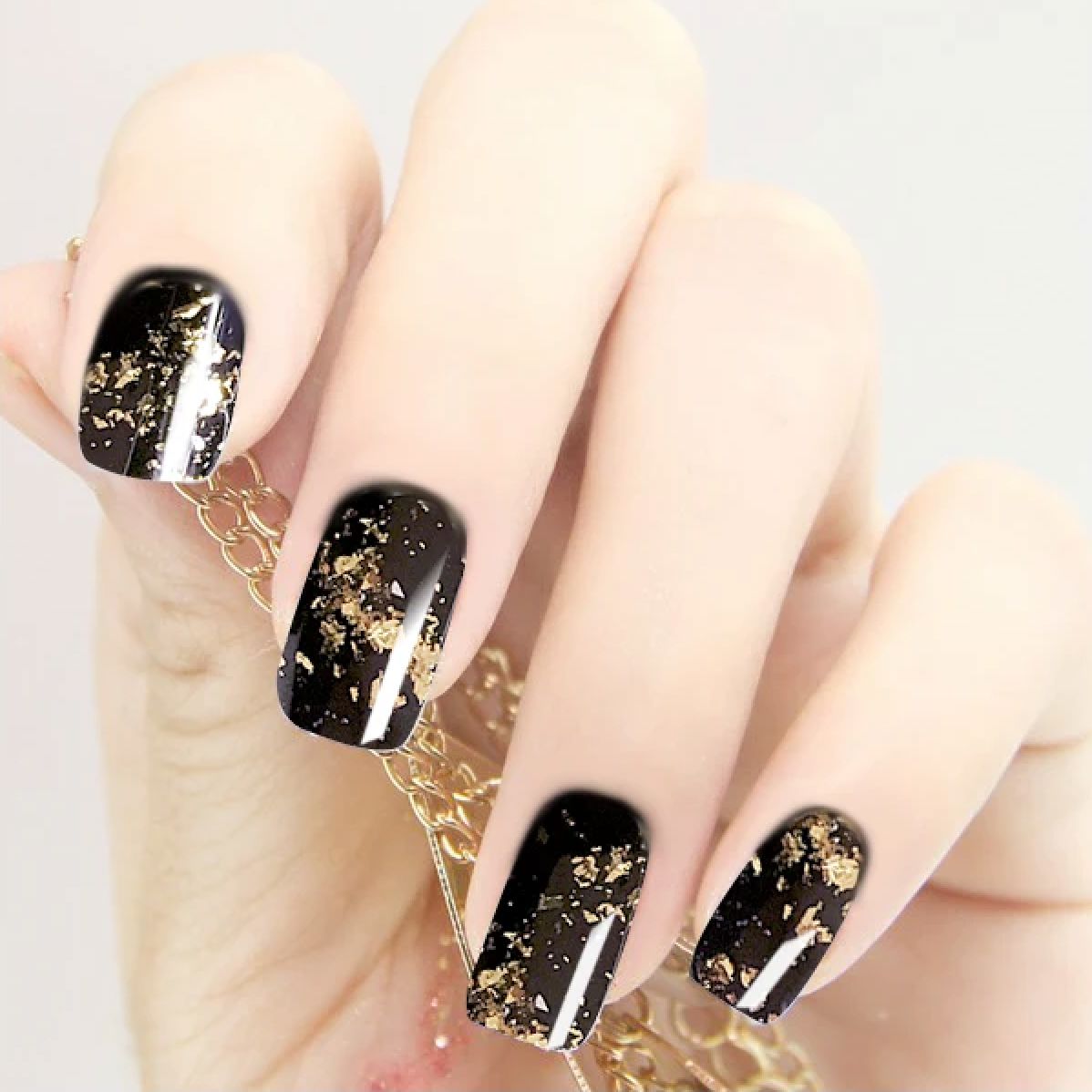 Gold chrome flakes on black gel nails — metallic foil effect manicure, NSI Australia