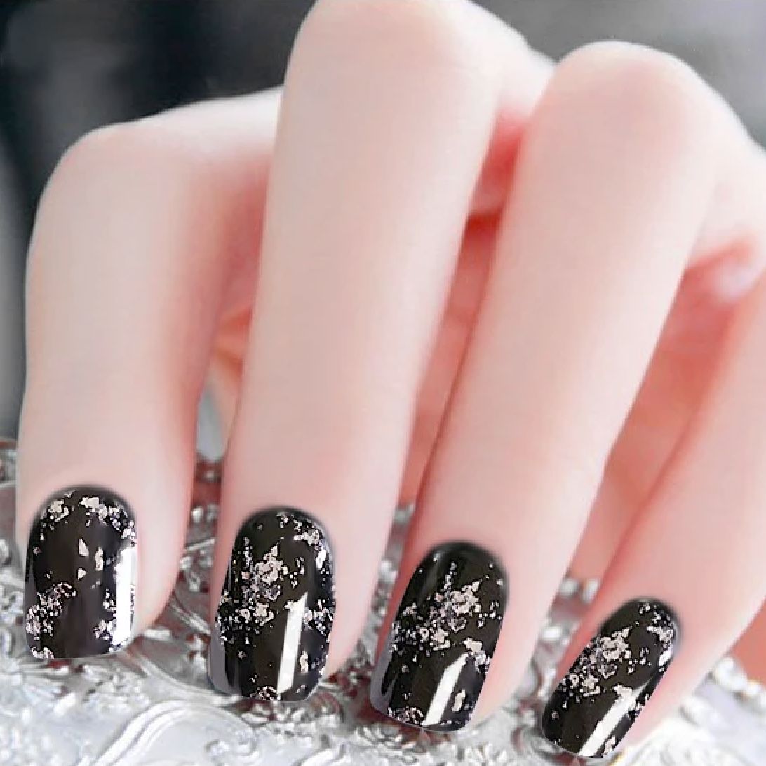 Silver chrome flake nail art on glossy black gel polish — elegant flake effect manicure