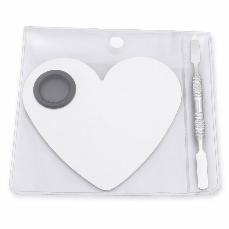 White heart-shaped nail art mixing palette with stainless steel spatula tool in clear storage pouch for gel polish blending and salon nail designs
