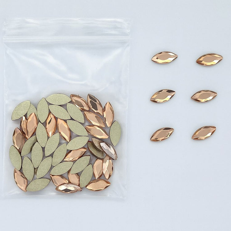 Gold marquise-shaped nail art rhinestones — faceted flatbacks in zip bag with loose samples (NSI Australia)