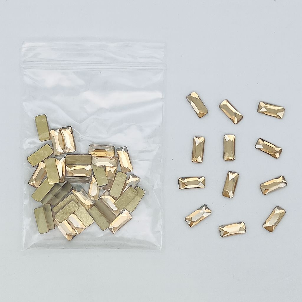 NSI Australia Luxury Rhinestones Series 6 — R07 rectangular bar champagne-gold faceted flatback nail art crystals, bulk bag with loose pieces shown