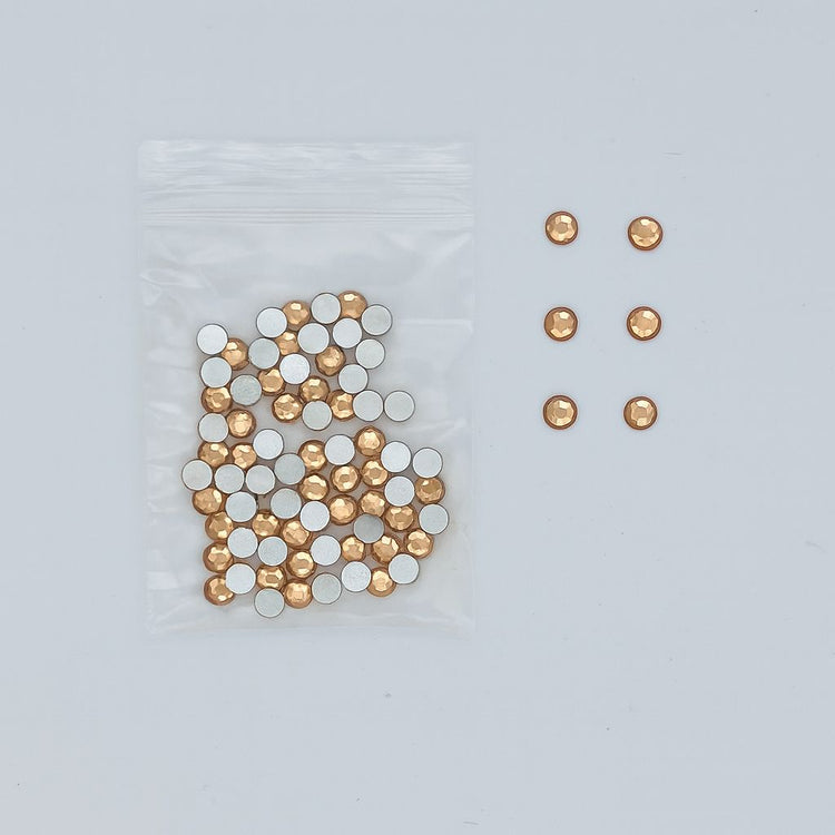 NSI Australia Luxury Rhinestones Series 6 — R14 round champagne-gold flatback nail art rhinestones, 3.5 mm, bulk bag with a few pieces shown