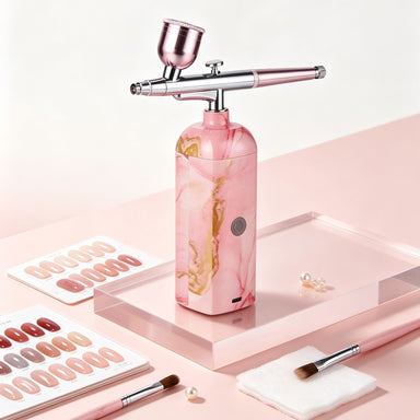 Pink portable cordless nail airbrush machine for creating ombré effects, gradients and detailed nail art
