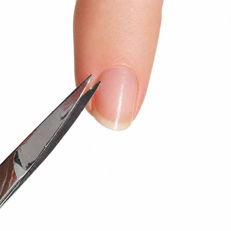 Nail Success Australia stainless steel nail and cuticle scissors trimming cuticles beside a natural fingernail for precise manicure grooming