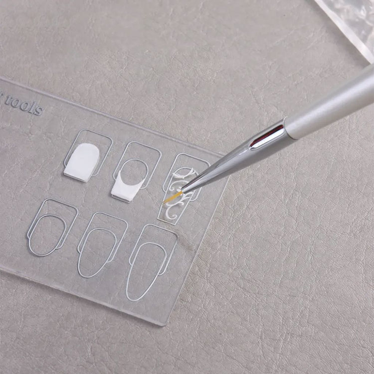 Clear nail art design palette with nail shape guides and detail brush painting white gel nail artwork