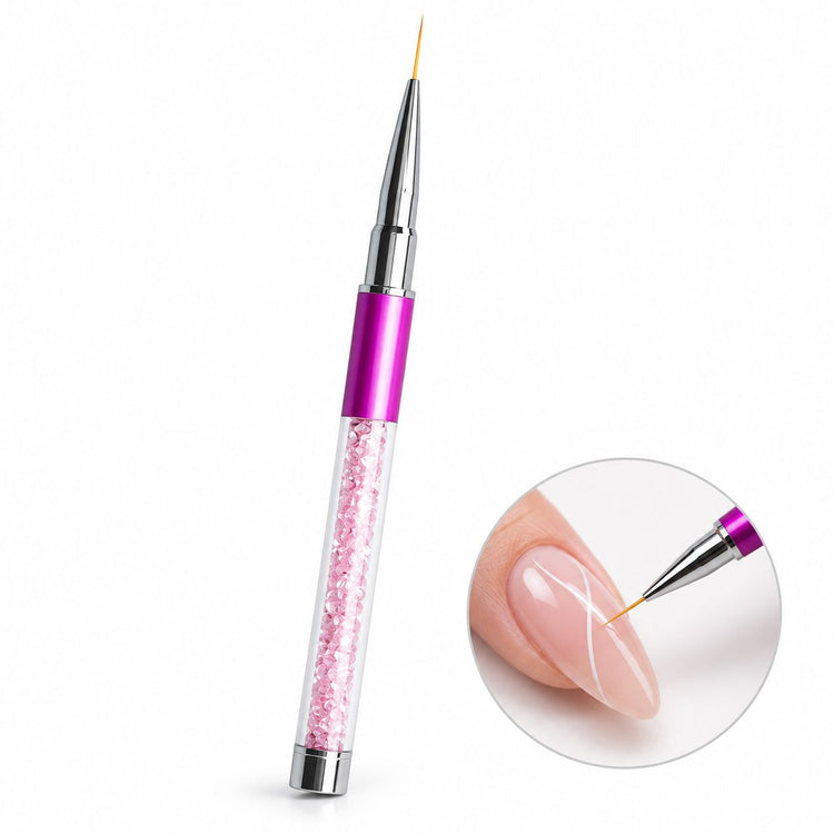 Pink 11 mm nail art liner brush with crystal-filled handle, shown painting fine white curves on a nude pink nail.