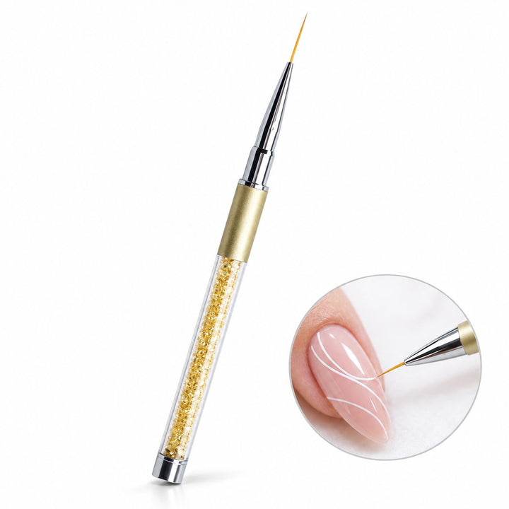 Gold 20 mm nail art liner brush with crystal-filled handle, shown painting fine white curves on a nude pink nail.