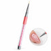 8 mm nail art liner brush with coral grip and pink crystal-filled handle, shown painting white leaf outlines on a nude pink nail.