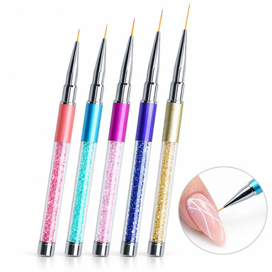 Set of five multicolour nail art liner brushes with crystal-filled handles and 8–20 mm tips, shown painting white curves on a nude pink nail.