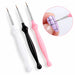 Set of three nail art liner brushes with white, black and pink handles, shown painting fine black grid lines on a lilac nail.