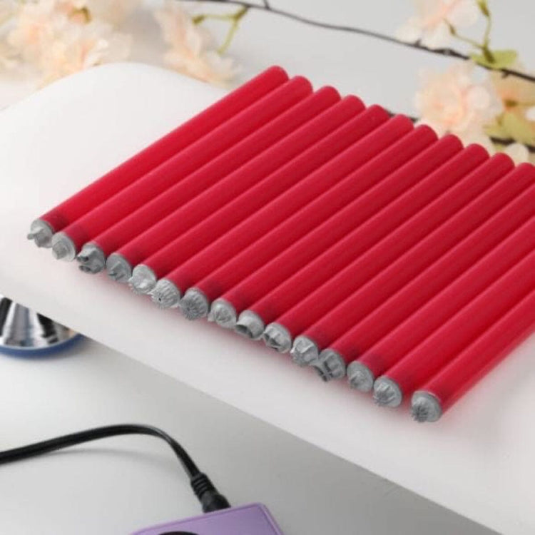 Row of red handled nail art pattern pens laid out on a white nail desk