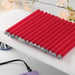Row of red handled nail art pattern pens laid out on a white nail desk