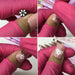Four close ups of the stamp pen pressing white flower designs onto a pink nail