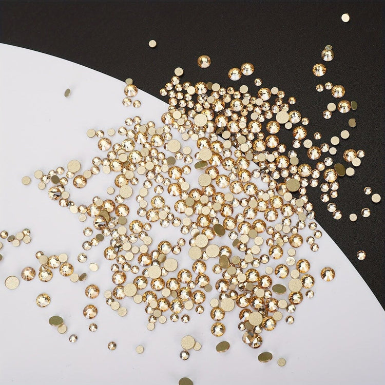 Gold nail art rhinestones — mixed-size flatback crystals scattered on black & white surface — NSI Australia