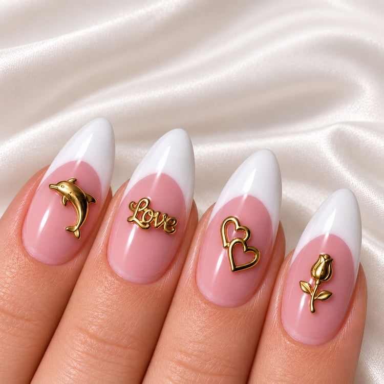 Pink and white French almond manicure decorated with gold dolphin, “Love”, double-heart and rose nail charms.
