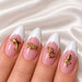 Pink and white French almond manicure decorated with gold dolphin, “Love”, double-heart and rose nail charms.