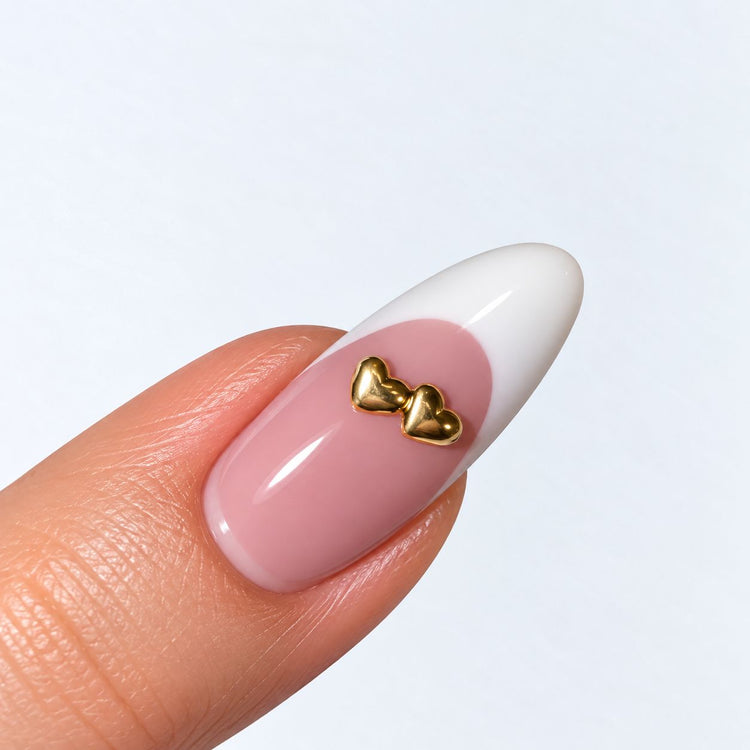 Gold plated two full hearts nail charm on a pink and white French almond nail, NSI Australia