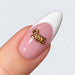 Gold plated Love word nail charm on a pink and white French almond nail, NSI Australia