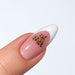 Gold plated Oh Shit word nail charm on a pink and white French almond nail, NSI Australia