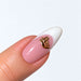 Gold plated Sexy word nail charm on a pink and white French almond nail, NSI Australia