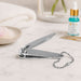 Nail Success Australia travel nail clipper with built-in keychain shown on manicure table with cuticle oil in background
