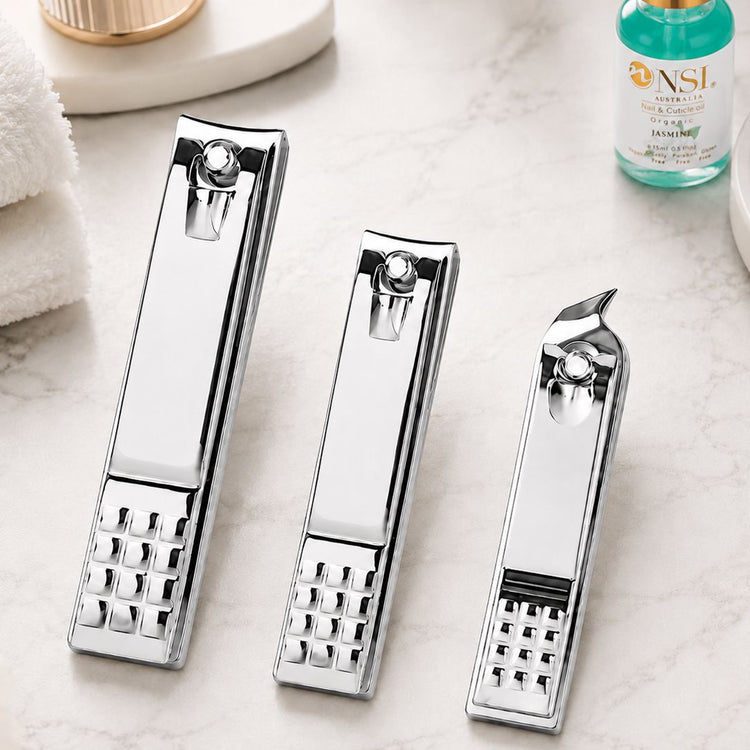 Silver nail clippers 3pcs set displayed on marble salon surface with NSI nail and cuticle oil, NSI Australia
