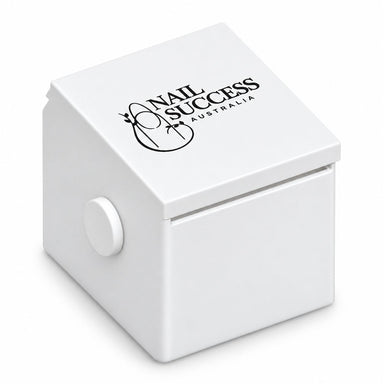 Compact white nail form dispenser with a black Nail Success Australia logo on the sloping lid, a front dispensing slot and round side knob.
