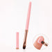 Pink gel nail brush with rounded tip, rose gold ferrule and matching cap, shown applying gel to a natural nail.
