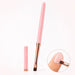 Pink gel nail brush with flat square bristles, rose gold ferrule and matching cap, shown applying gel to a natural nail.
