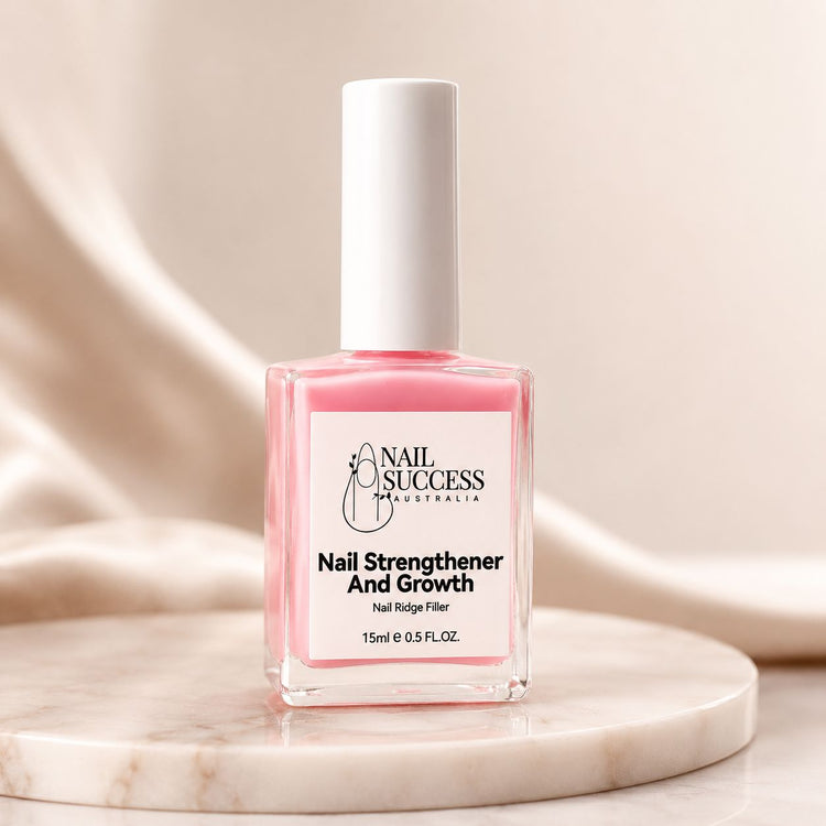 Nail Success Australia nail strengthener and growth treatment bottle on marble display with pink formula, white cap and nail ridge filler label