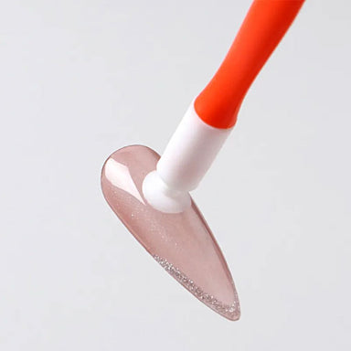 Orange nail suction cup stick holding a glitter false nail tip for gel polish application, nail art practice and manicure display work
