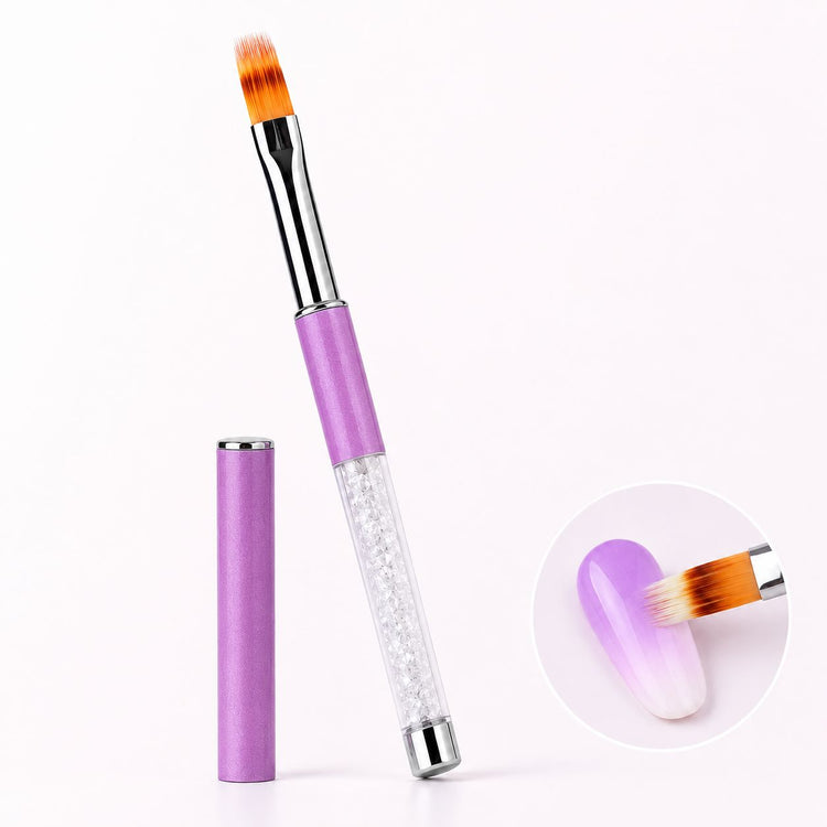 Light purple ombré gel brush with feathered bristles, crystal-filled handle and matching cap, shown blending purple and white on a nail.
