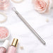 Stainless steel gel polish remover peeler scraper tool on marble background with nail polish and rose