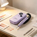 Purple portable electric nail drill with digital speed display and handpiece on a professional manicure table.
