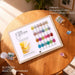 24 color magic chrome nail powder swatch chart on wooden table with chrome pigment jars