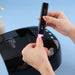 UV flash torch curing gel polish on thumb, black portable rechargeable nail lamp in use.