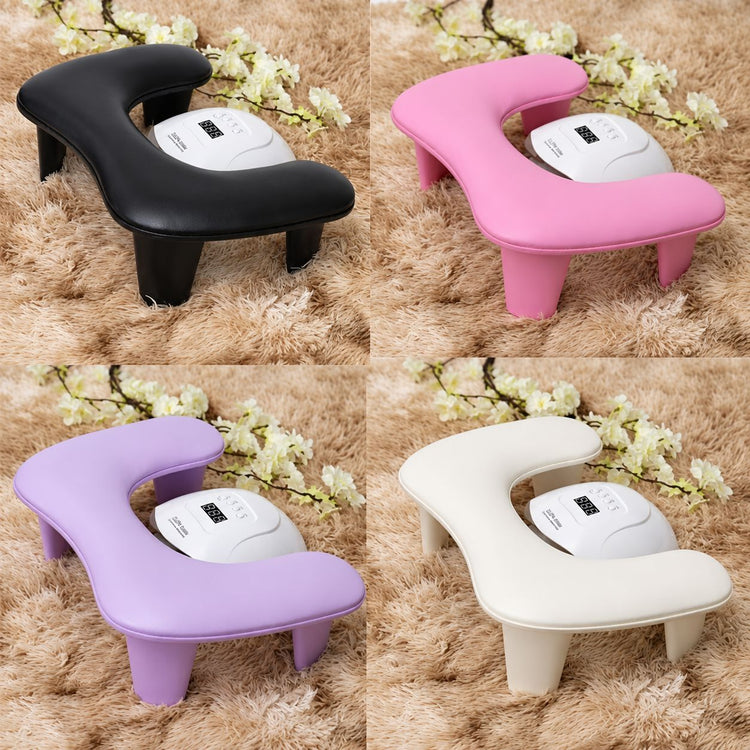 Pro Relax hand and arm rest pillows in black, pink, lilac and cream, each shown positioned around a white nail lamp.