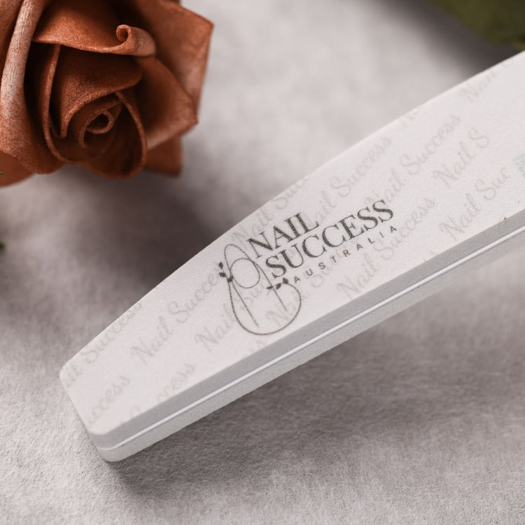 240 grit—close-up of curved foam buffer with logo, styled with a rose