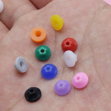 Mixed colour nail drill bit dust protector caps shown in hand, assorted silicone caps for e-file bits to help reduce dust entry and protect manicure drill handpieces