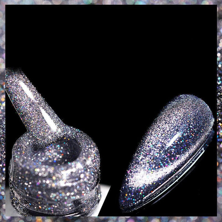 Reflective glitter cat eye magnetic gel polish in silver with sparkling holographic finish, shown on a nail tip and brush for shimmering nail art designs