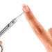 Close-up of precision cuticle scissors pointing toward a natural fingernail to show fine tip detail and trimming accuracy