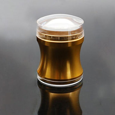Gold nail art stamper with a clear 4 cm diameter head, displayed on a reflective black surface.
