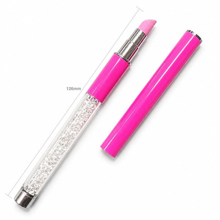 Pink stone cuticle file pen shown open on a light gray background, with a crystal-filled clear handle and a pink abrasive tip