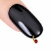 Black glossy nail with gold red rhinestone dangle charm for nail piercing and creative salon nail art designs