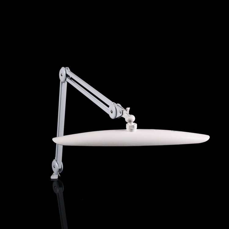 Nail Success Australia StudioFlex LED nail desk lamp — slim shadowless panel on adjustable arm, side view on black background