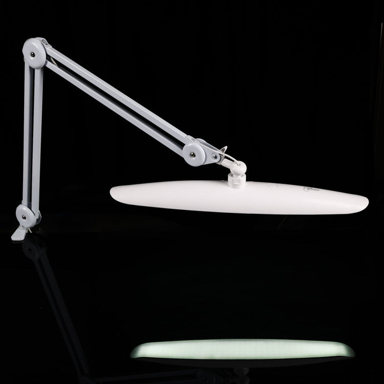 Nail Success Australia StudioFlex LED nail desk lamp — slim shadowless panel on adjustable arm, side view on black background with reflection